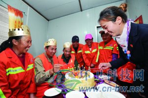 社區(qū)工作人員為集體過生日的三名環(huán)衛(wèi)工人點(diǎn)上生日蠟燭。 本報通訊員 趙松 攝